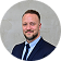Stefan Tochev smiling in a suit and tie